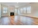 Bright living room with a fireplace and large windows, showcasing beautiful hardwood floors at 6800 Franklin Heights Rd, Cary, NC 27518