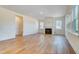 Open-concept living room with a fireplace, light walls, and beautiful hardwood floors at 6800 Franklin Heights Rd, Cary, NC 27518