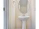 Powder room with pedestal sink, modern faucet, and decorative mirror at 6800 Franklin Heights Rd, Cary, NC 27518