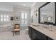 Bright bathroom featuring marble floors, a vanity, a soaking tub, and a charming accent chair at 809 Wayne Dr, Raleigh, NC 27608