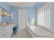 Bright bathroom with a soaking tub, marble countertops, and a crystal chandelier at 809 Wayne Dr, Raleigh, NC 27608