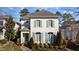Charming two-story home with painted brick exterior, shutters, mature landscaping, and brick walkway at 809 Wayne Dr, Raleigh, NC 27608