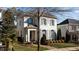 Charming two-story home with painted brick exterior, shutters, mature trees, and brick walkway at 809 Wayne Dr, Raleigh, NC 27608