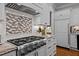 Kitchen area featuring a large stainless-steel stove and custom backsplash at 809 Wayne Dr, Raleigh, NC 27608