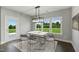 Bright dining room featuring modern chandelier, table and chairs with views of the lush outdoors at 73 Merle Dr, Wendell, NC 27591