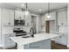 This modern kitchen features sleek white cabinets, stainless steel appliances, an island and pendant lighting at 73 Merle Dr, Wendell, NC 27591
