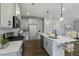 This modern kitchen features sleek white cabinets, stainless steel appliances, an island and pendant lighting at 73 Merle Dr, Wendell, NC 27591