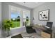 Bright office space with a modern glass desk and large windows overlooking the green landscape at 54 Merle Dr, Wendell, NC 27591