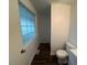 Compact bathroom features frosted window and toilet at 102 Sue Ave, Dunn, NC 28334