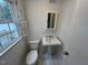 Bathroom featuring pedestal sink, toilet, and window at 102 Sue Ave, Dunn, NC 28334
