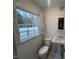 Bathroom featuring pedestal sink, toilet, and window with shutters at 102 Sue Ave, Dunn, NC 28334