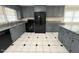 Updated kitchen featuring gray cabinets, granite countertops, black appliances, and unique flooring at 102 Sue Ave, Dunn, NC 28334