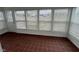 Sunroom with red tile floor and windows with blinds on all sides at 102 Sue Ave, Dunn, NC 28334