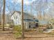 Lush backyard with a deck, sunroom, porch swing, and mature trees at 11424 Horsemans Trl, Raleigh, NC 27613