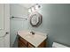 Bathroom with light blue walls, an octagon mirror, and a wood vanity at 11424 Horsemans Trl, Raleigh, NC 27613