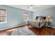 Comfortable bedroom features light blue walls, wood floors, and a ceiling fan at 11424 Horsemans Trl, Raleigh, NC 27613