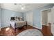 This bedroom features light blue walls, hardwood floors and a closet with a white louvered door at 11424 Horsemans Trl, Raleigh, NC 27613