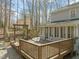 Large wooden deck with railings, seating area, and access to the sunroom at 11424 Horsemans Trl, Raleigh, NC 27613