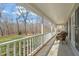 Spacious covered front porch with views of the landscaped yard and surrounding trees at 11424 Horsemans Trl, Raleigh, NC 27613