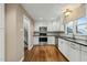 Well-lit kitchen featuring white cabinets, black countertops, and stainless steel appliances at 11424 Horsemans Trl, Raleigh, NC 27613