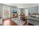 Cozy living room with hardwood floors and large windows allowing for natural light at 11424 Horsemans Trl, Raleigh, NC 27613