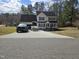 View of two story home with attached garage and long drive way, pickup truck and boat parked in driveway at 1201 Teakwood Ct, Sanford, NC 27330