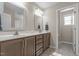 Bathroom vanity area has dual sinks, wood cabinets and a decorative mirror at 124 Brookstone Way, Angier, NC 27501