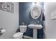Stylish powder room with blue accent wall, oval mirror and pedestal sink at 124 Brookstone Way, Angier, NC 27501