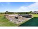 A stone patio with built-in seating and a central fire pit offers an outdoor entertaining space at 124 Brookstone Way, Angier, NC 27501