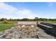 Outdoor stone patio with built in bench seating and a fire pit at 124 Brookstone Way, Angier, NC 27501