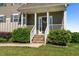 Inviting front entrance with stone steps, a white railing, and mature landscaping at 124 Brookstone Way, Angier, NC 27501