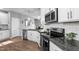 Well-lit kitchen featuring stainless appliances, granite counters, and white cabinetry at 124 Brookstone Way, Angier, NC 27501