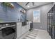 Well-lit laundry room features a stainless steel sink, granite countertops, and wood-look flooring at 124 Brookstone Way, Angier, NC 27501