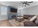 Spacious living room featuring a modern fireplace, a ceiling fan, and comfortable leather seating at 124 Brookstone Way, Angier, NC 27501