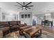 Spacious living room with leather sofa, ceiling fan, and view to dining area at 124 Brookstone Way, Angier, NC 27501