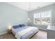 Comfortable bedroom features light blue walls, a chandelier, and bright natural light from the window at 124 Ferrell W Rd, Apex, NC 27523