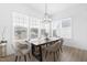 Sunlit dining room with a wooden table, modern chairs, and large windows overlooking the backyard at 124 Ferrell W Rd, Apex, NC 27523