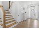 Bright foyer features wood floors, a staircase, and a front door with decorative light fixture at 124 Ferrell W Rd, Apex, NC 27523