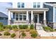 Inviting front porch with stone accents, dark door with wreath, and manicured landscaping enhance curb appeal at 124 Ferrell W Rd, Apex, NC 27523