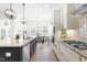 Bright kitchen boasts white cabinetry, stainless appliances, granite counters, and eat-in breakfast area at 124 Ferrell W Rd, Apex, NC 27523