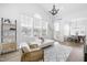 Bright living room with a decorative chandelier, large windows, modern furniture, and an open-concept layout with dining area at 124 Ferrell W Rd, Apex, NC 27523