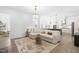 Inviting living room with hardwood floors, large sectional, and kitchen in background at 124 Ferrell W Rd, Apex, NC 27523