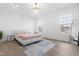 Bright main bedroom featuring a modern chandelier, neutral color palette, hardwood floors, and multiple windows at 124 Ferrell W Rd, Apex, NC 27523