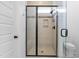 Modern shower with a glass door, bench, mosaic tile accent, and tiled walls at 124 Ferrell W Rd, Apex, NC 27523
