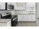 Well-lit kitchen with stainless steel oven/microwave, white cabinets, and granite counters at 1306 Plexor Ln, Knightdale, NC 27545