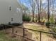 Backyard view of a light gray two-story home, with a walkway, trees, and a partially fenced yard at 1404 Vanguard Pl, Durham, NC 27713