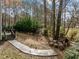 Expansive backyard featuring mature trees, a wooden walkway, and a charming wooded area perfect for outdoor activities at 1404 Vanguard Pl, Durham, NC 27713