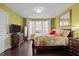 Comfortable bedroom with hardwood floors, a large window, and a dresser with a wall-mounted television at 1404 Vanguard Pl, Durham, NC 27713