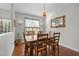 Cozy dining room featuring a wood table, elegant chandelier, and a view of the fenced-in backyard at 1404 Vanguard Pl, Durham, NC 27713