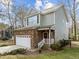 Front exterior of the home with a two-car garage, stone facade, and a well-manicured lawn at 1404 Vanguard Pl, Durham, NC 27713